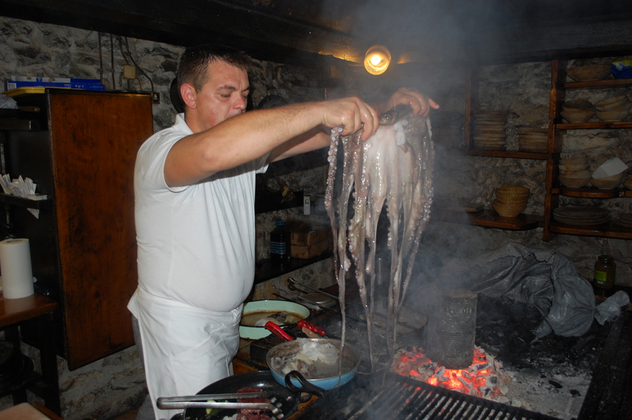 Stipe Slišković polaže hobotnicu na gradele čime počinje pripremu hobotnice za peku